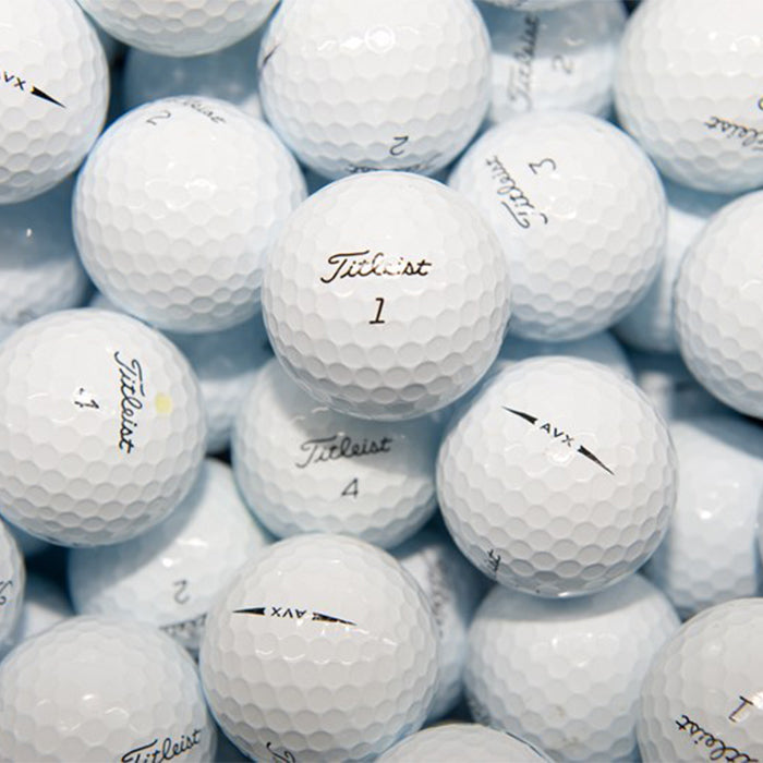 A pile of white Titleist AVX golf balls with visible branding on them.